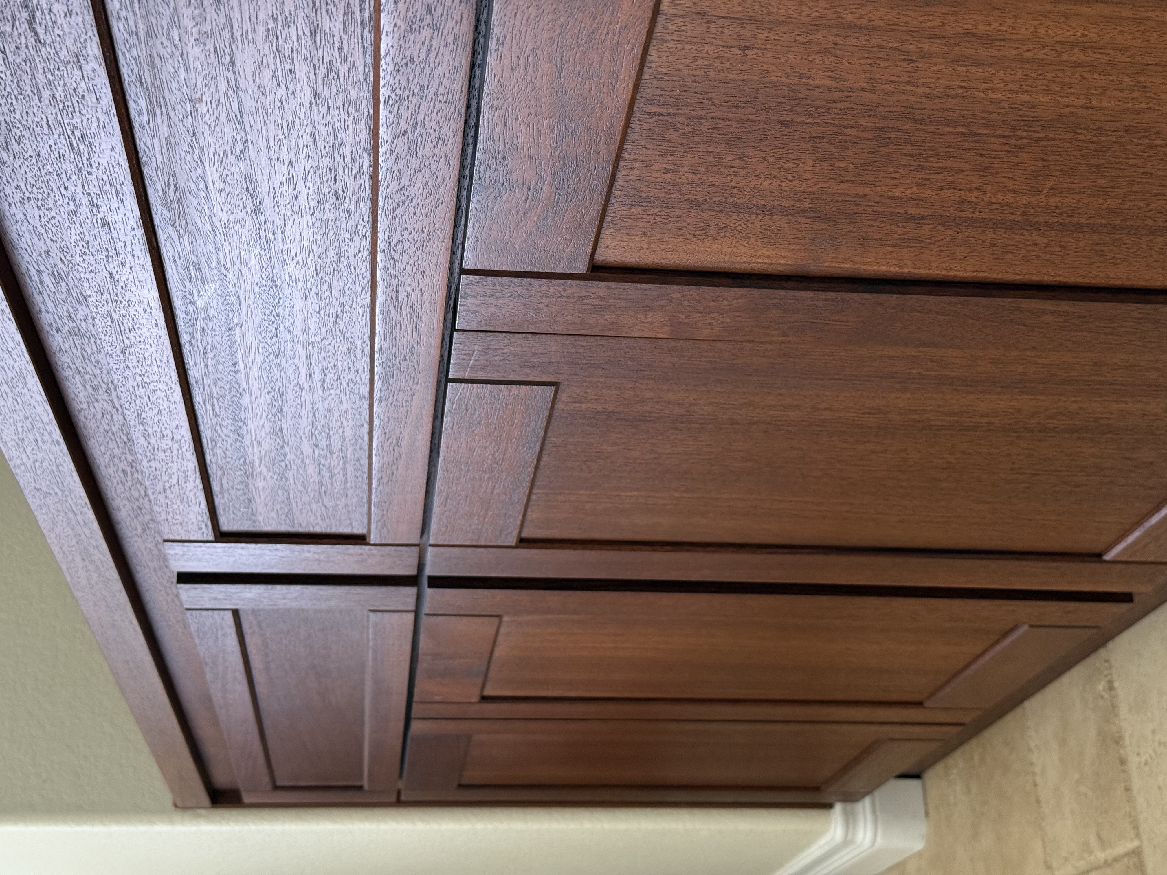 Solid mahogany built-in console with shaker-style cabinet doors and drawers, fitted into a wall alcove