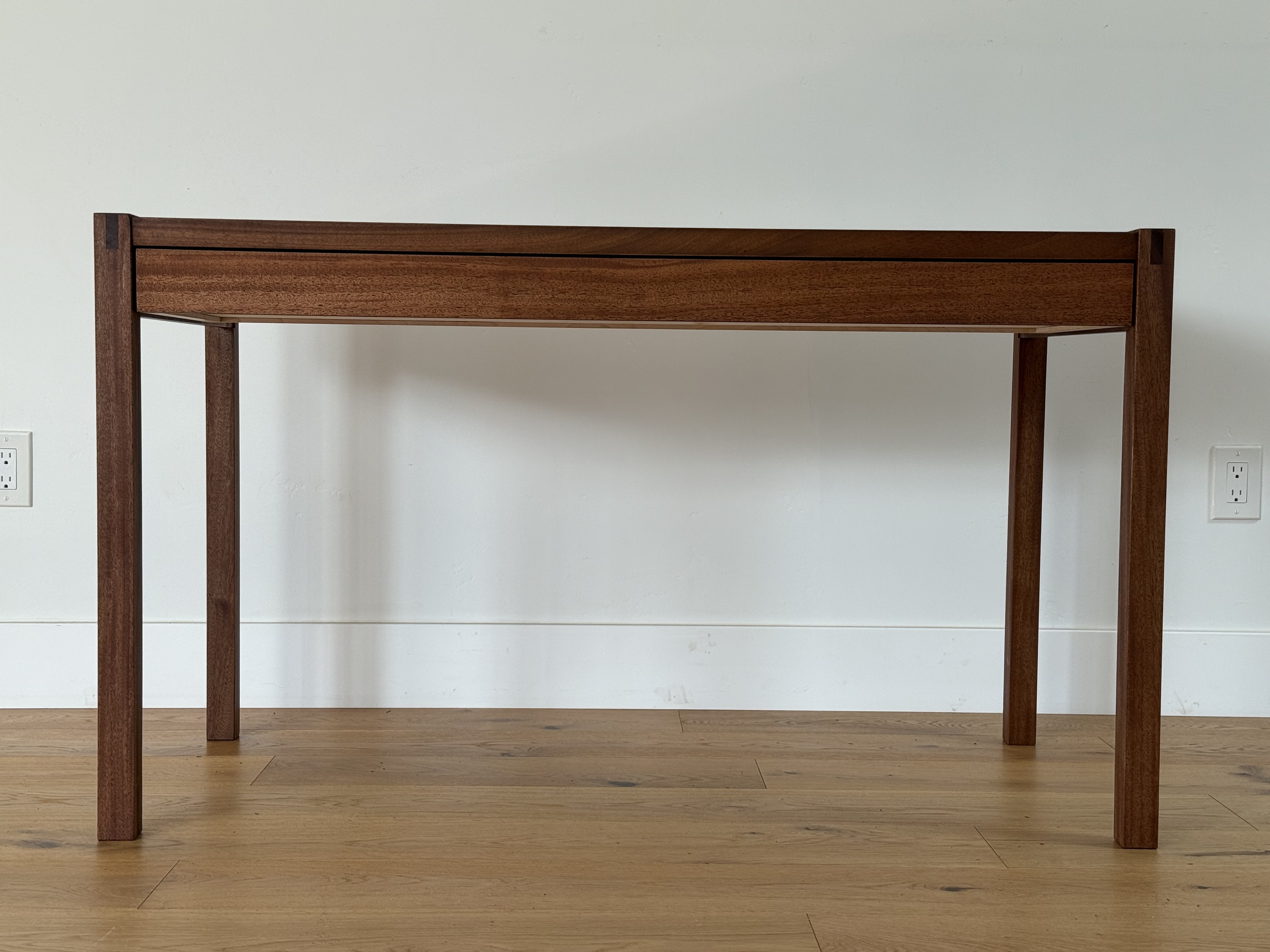 African Mahogany desk, angled three-quarter view showing through-tenon leg joinery