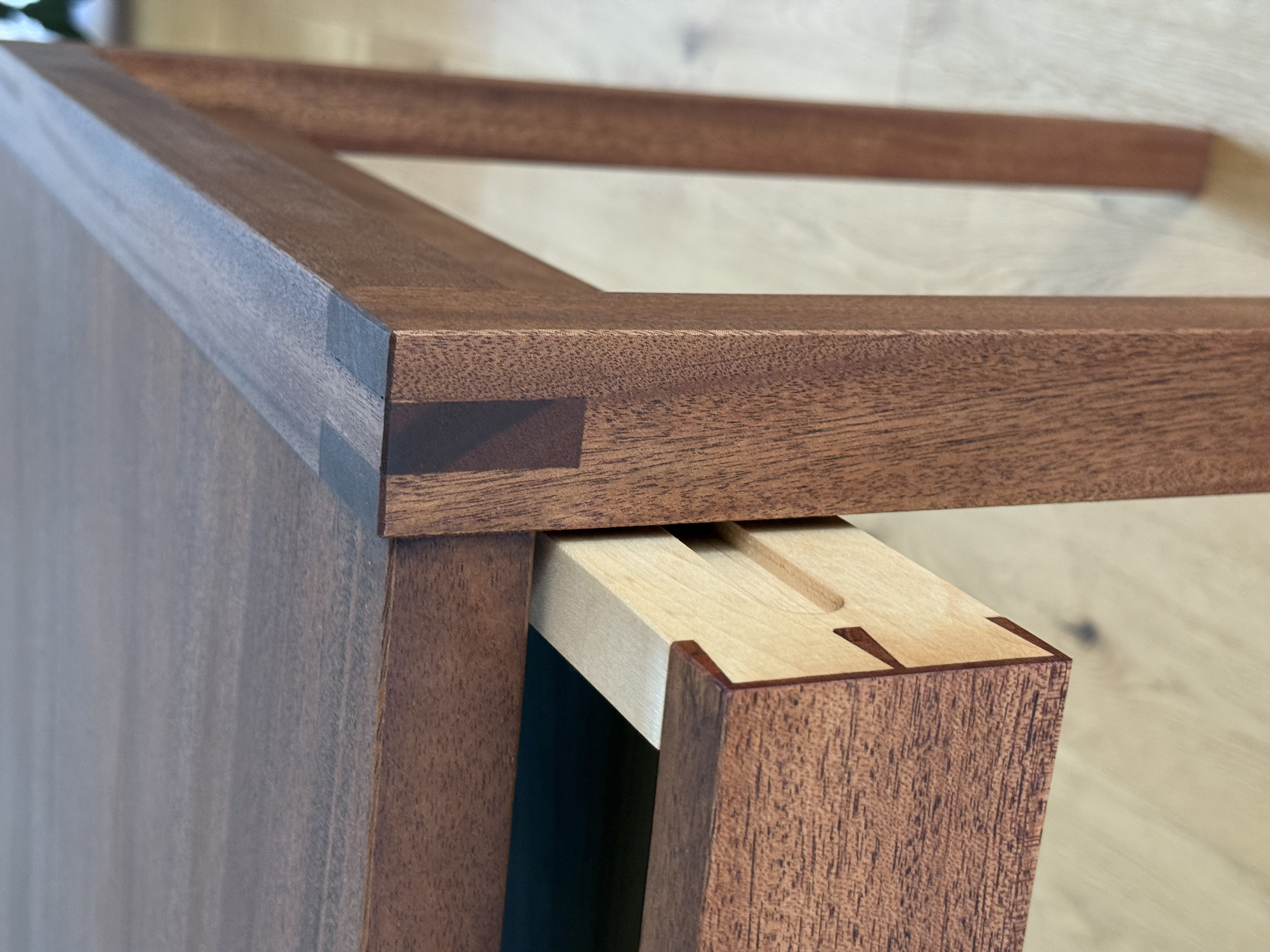 Close-up of African Mahogany desk corner, through-tenon joint and drawer