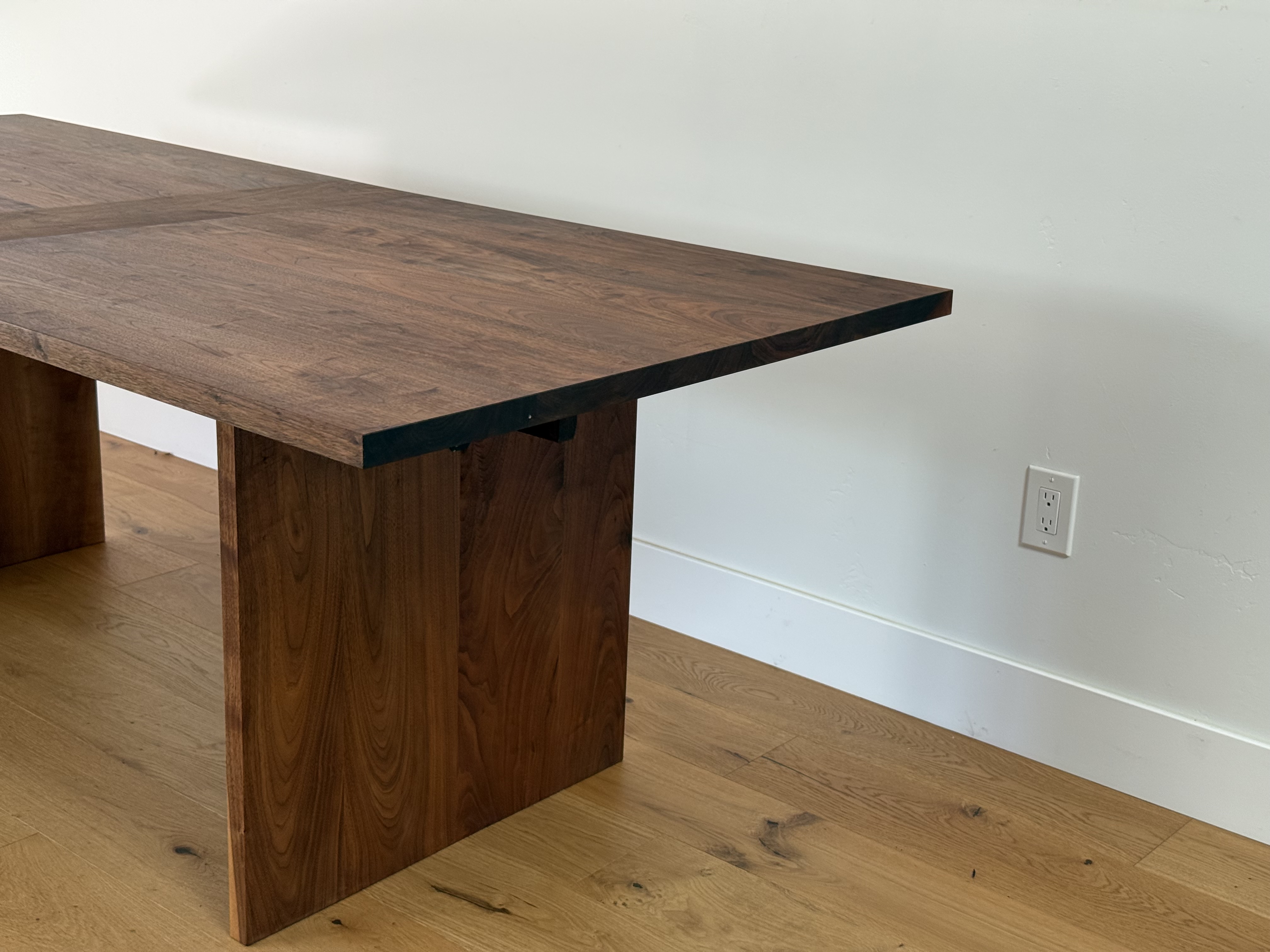 Walnut dining table detail, tabletop and paneled leg joinery