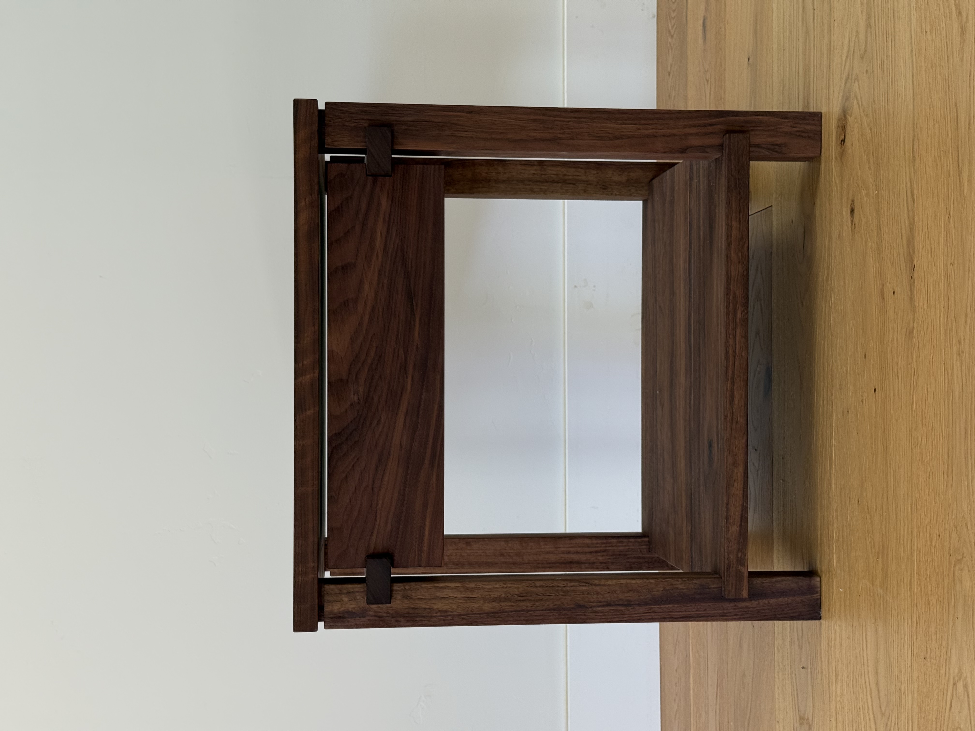 Walnut nightstand, front view, two open shelves and a drawer