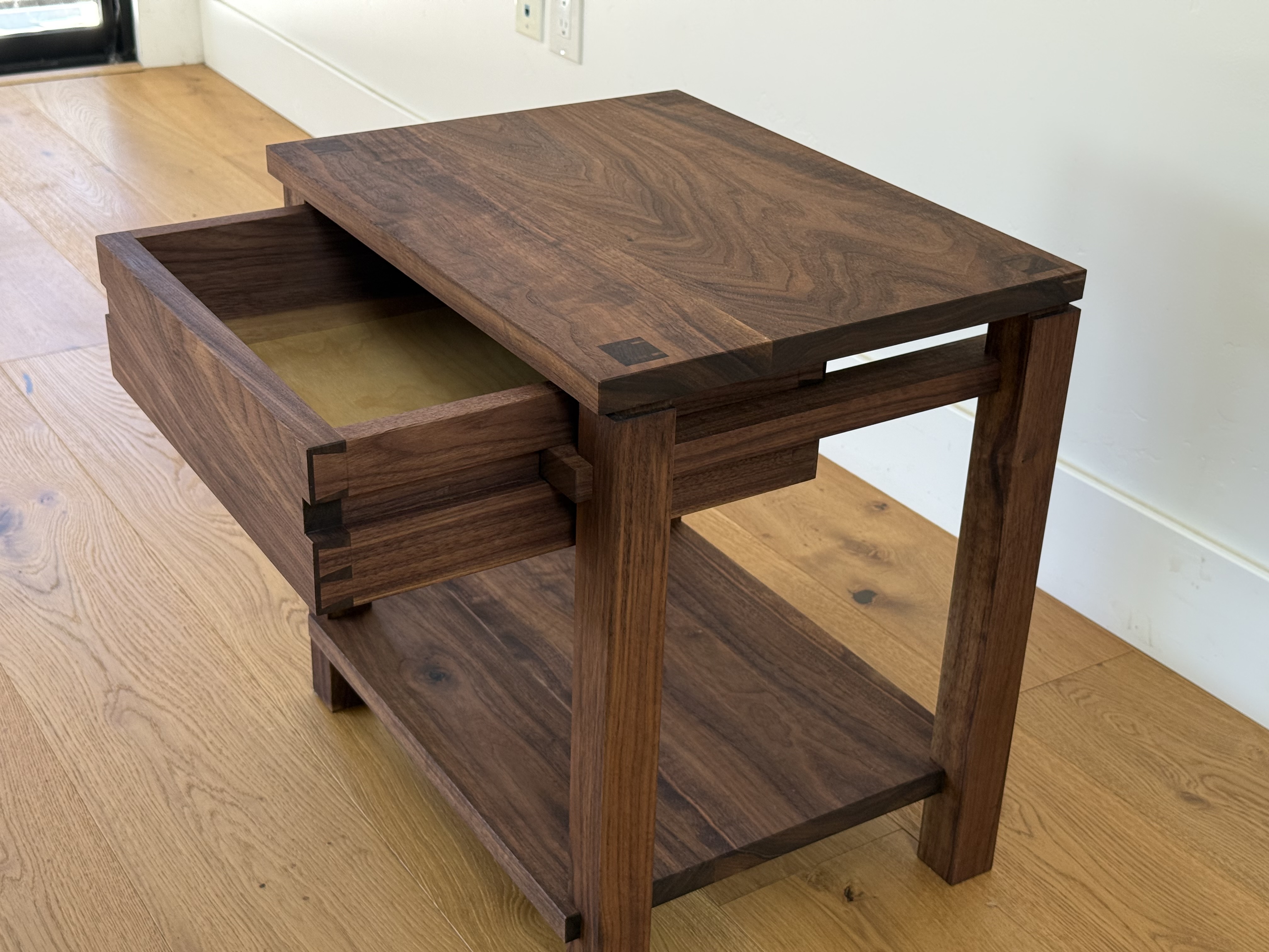 Walnut nightstand, angled view with drawer open showing dovetail joinery